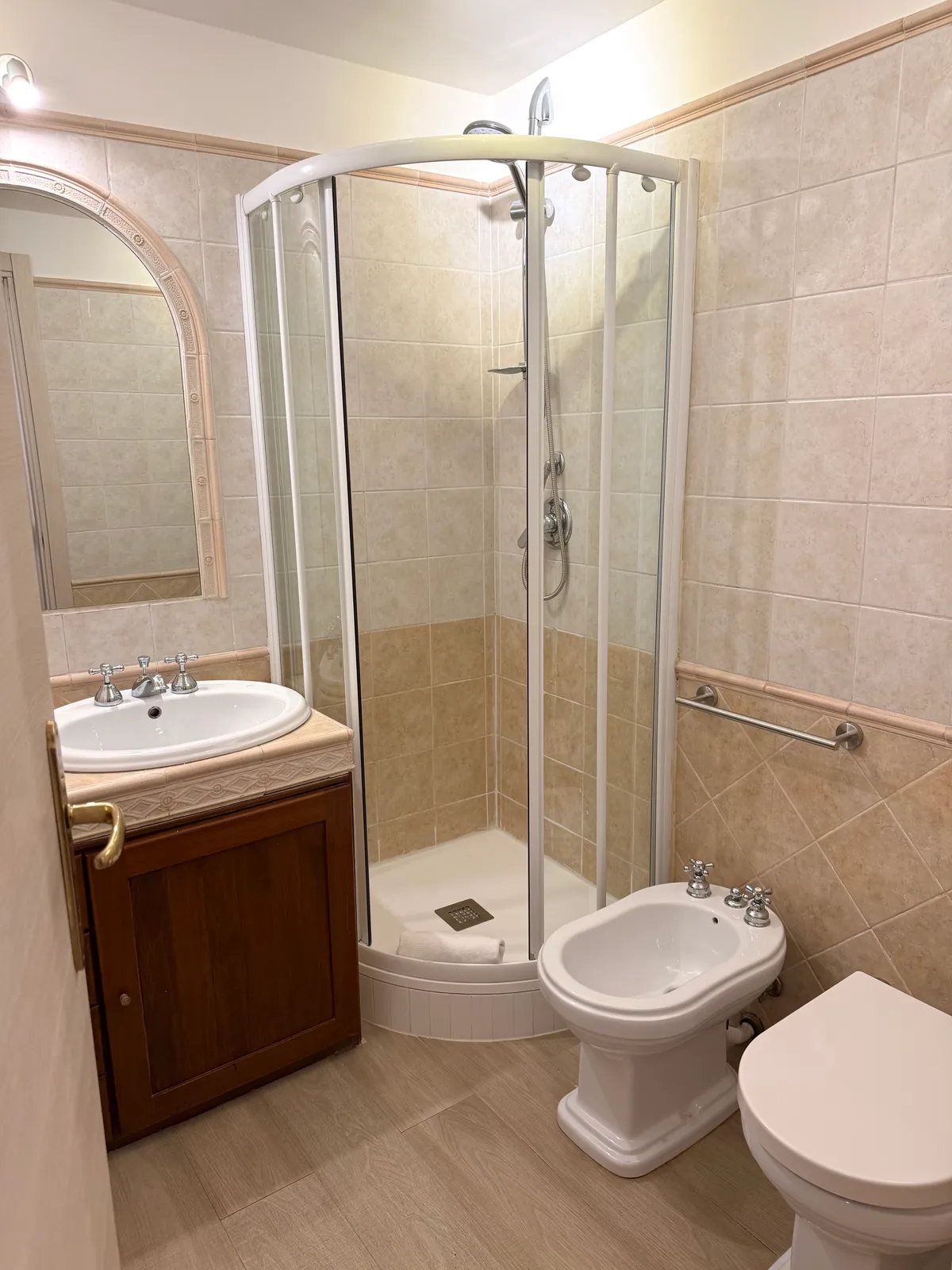 Il bagno della camera 1 con specchio ad arco, doccia e sanitari
