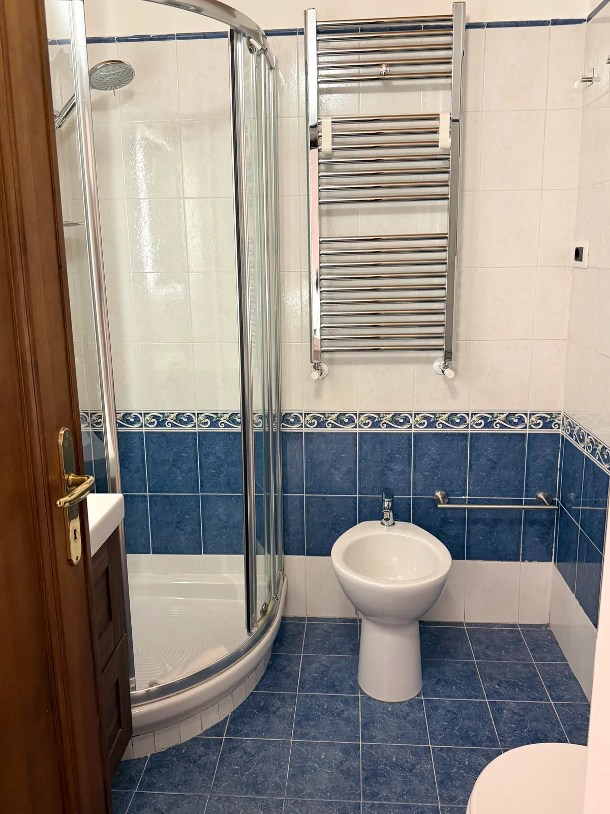 La doccia del bagno della camera 2, con le piastrelle blu