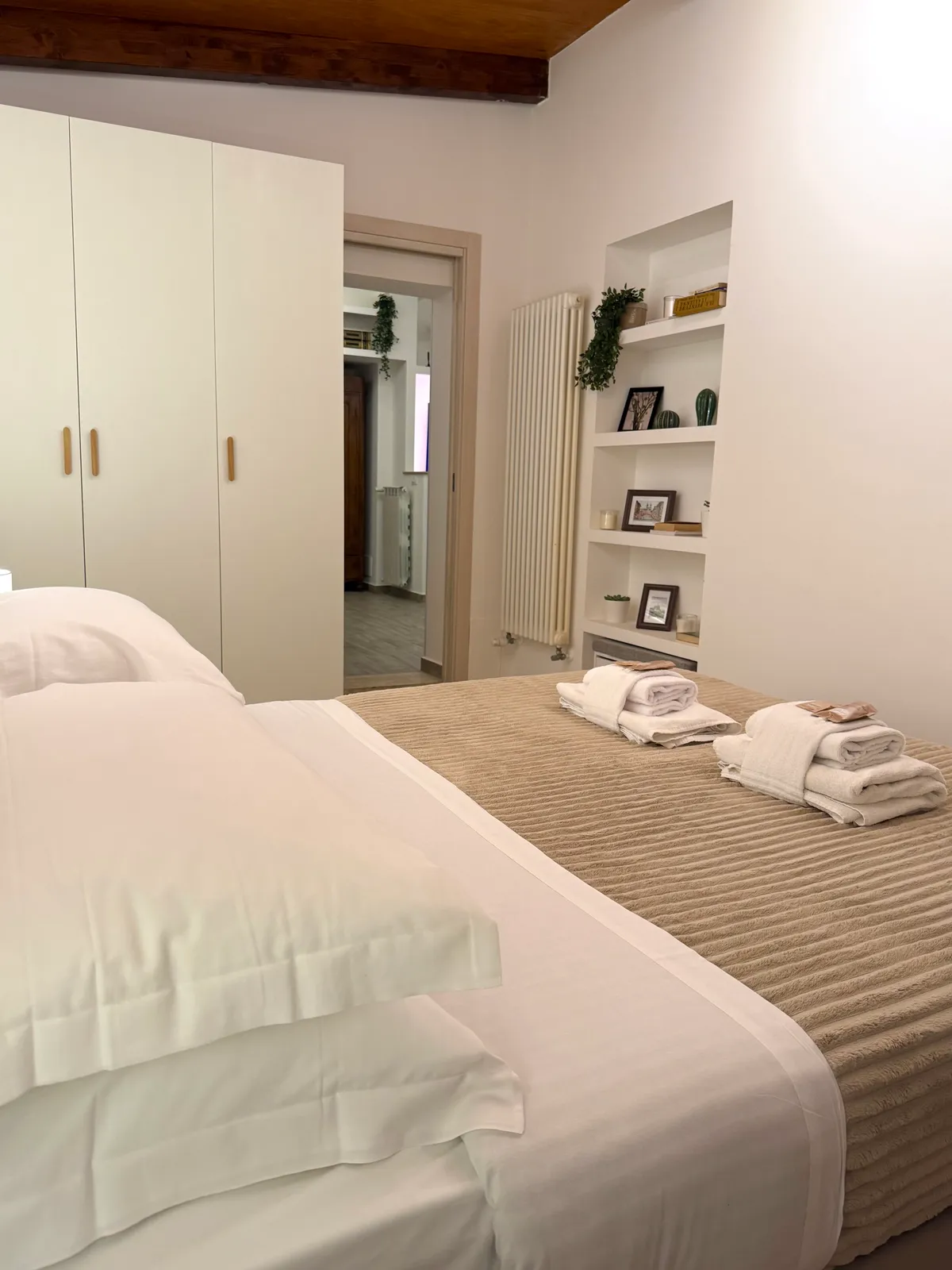 Il letto e l'armadio bianco, con la libreria a muro