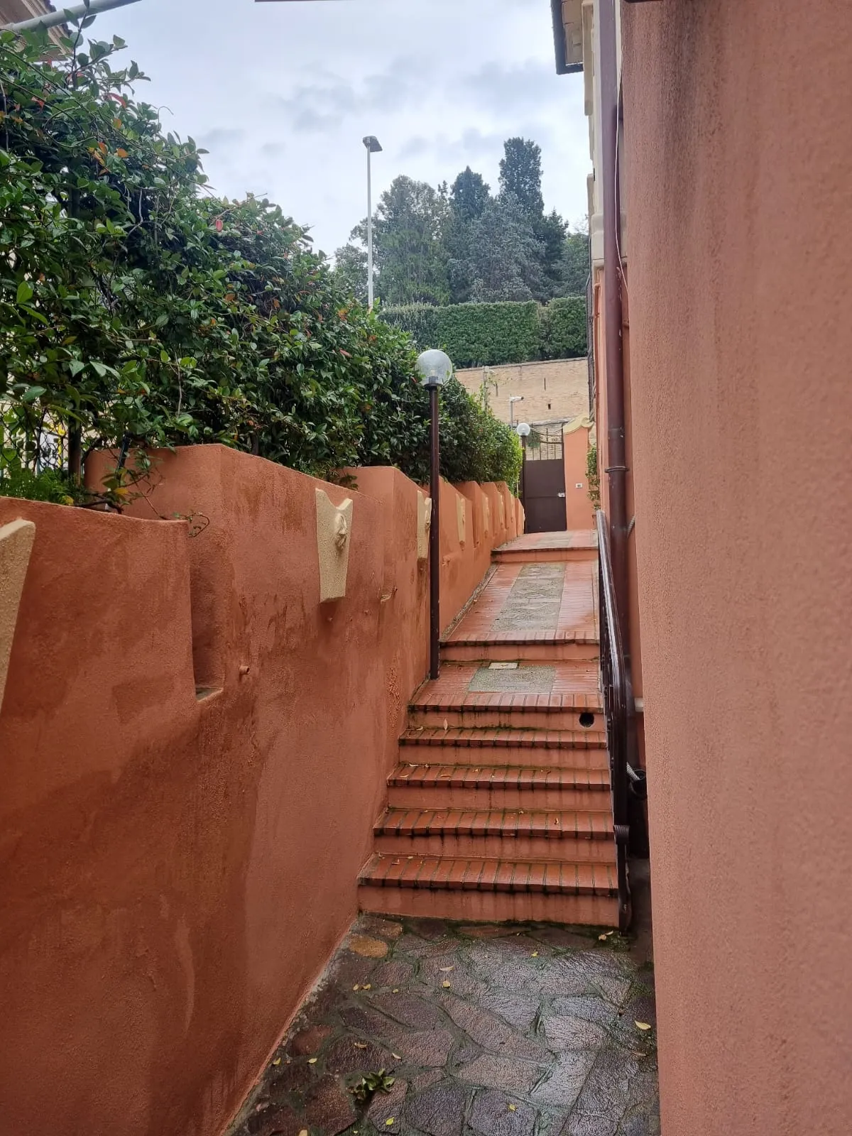 I gradini in cotto lungo il muro rosa, verso l'ingresso