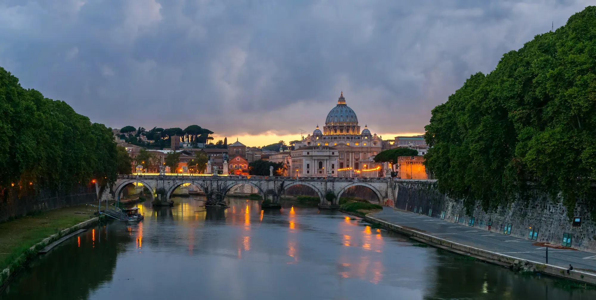 Il Tevere al tramonto con Ponte Sant'Angelo e la cupola di San Pietro sullo sfondo
