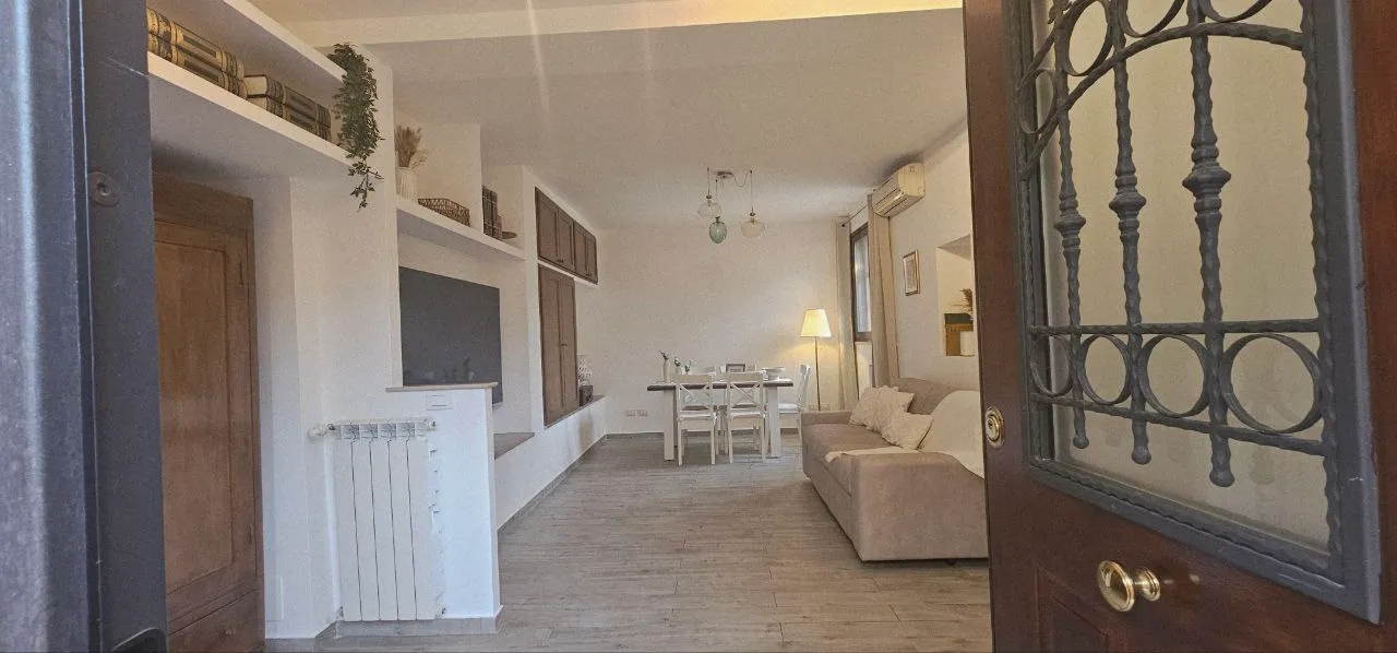 Il soggiorno visto dalla porta d'ingresso con la grata in ferro battuto