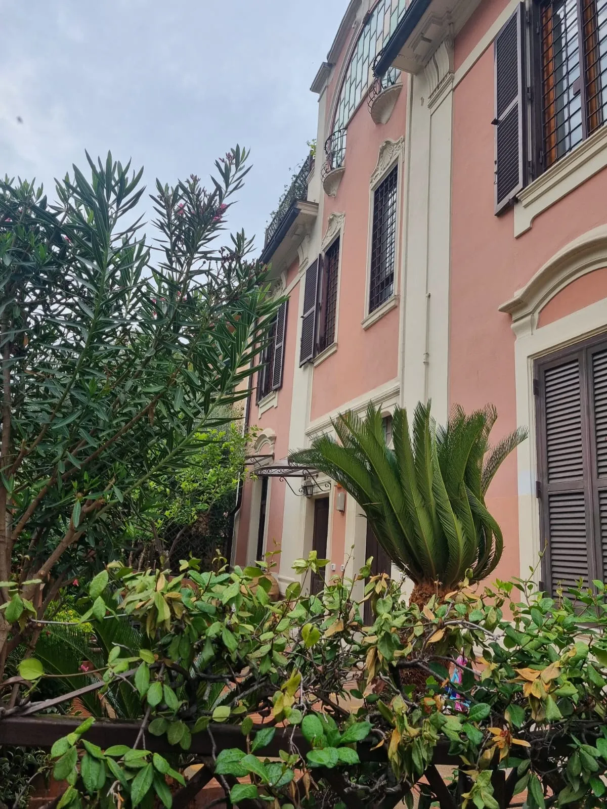 La facciata rosa del villino tra oleandri e cycas